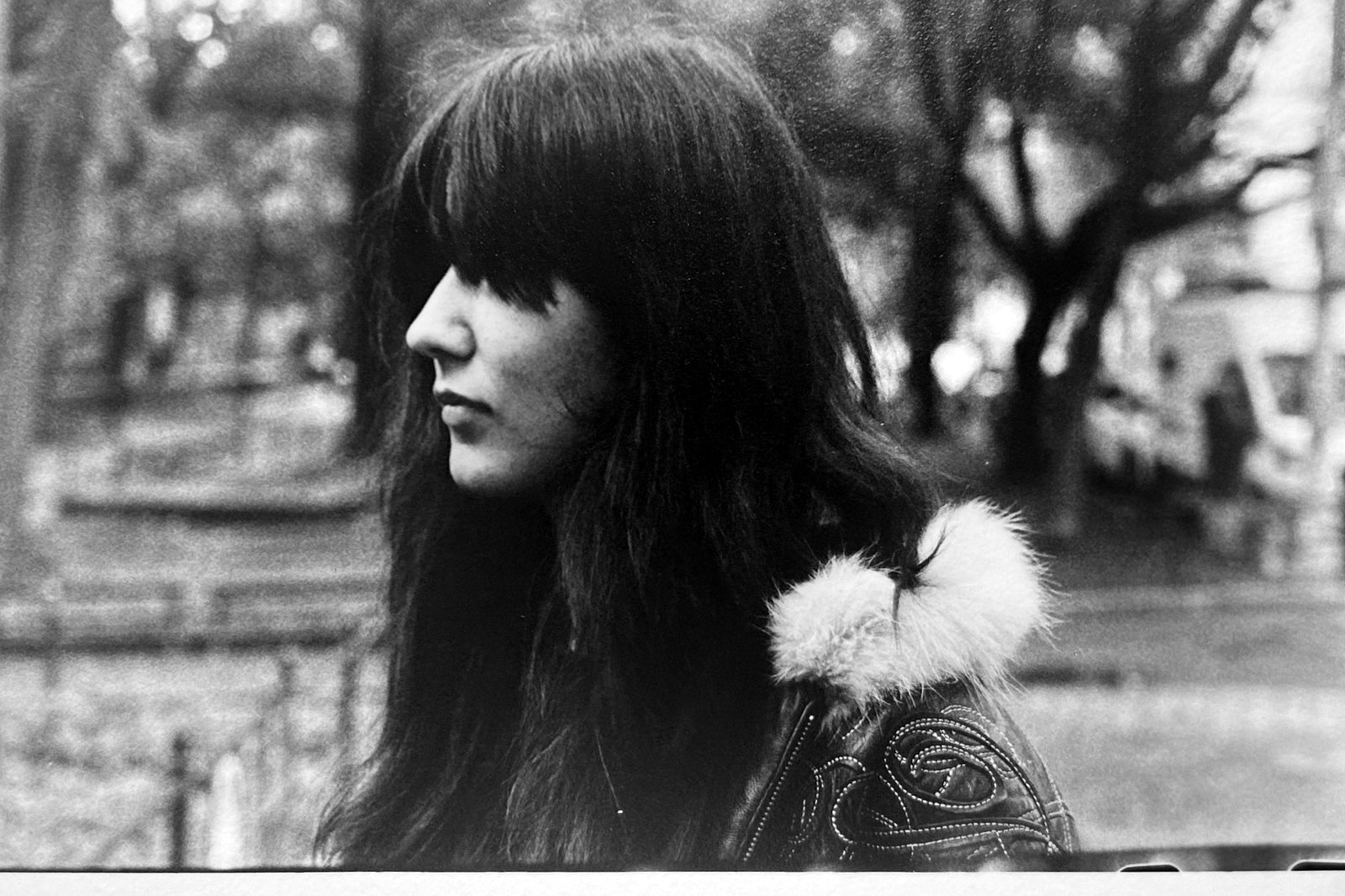 Black and white portrait of a woman in profile outdoors, hair across her face.